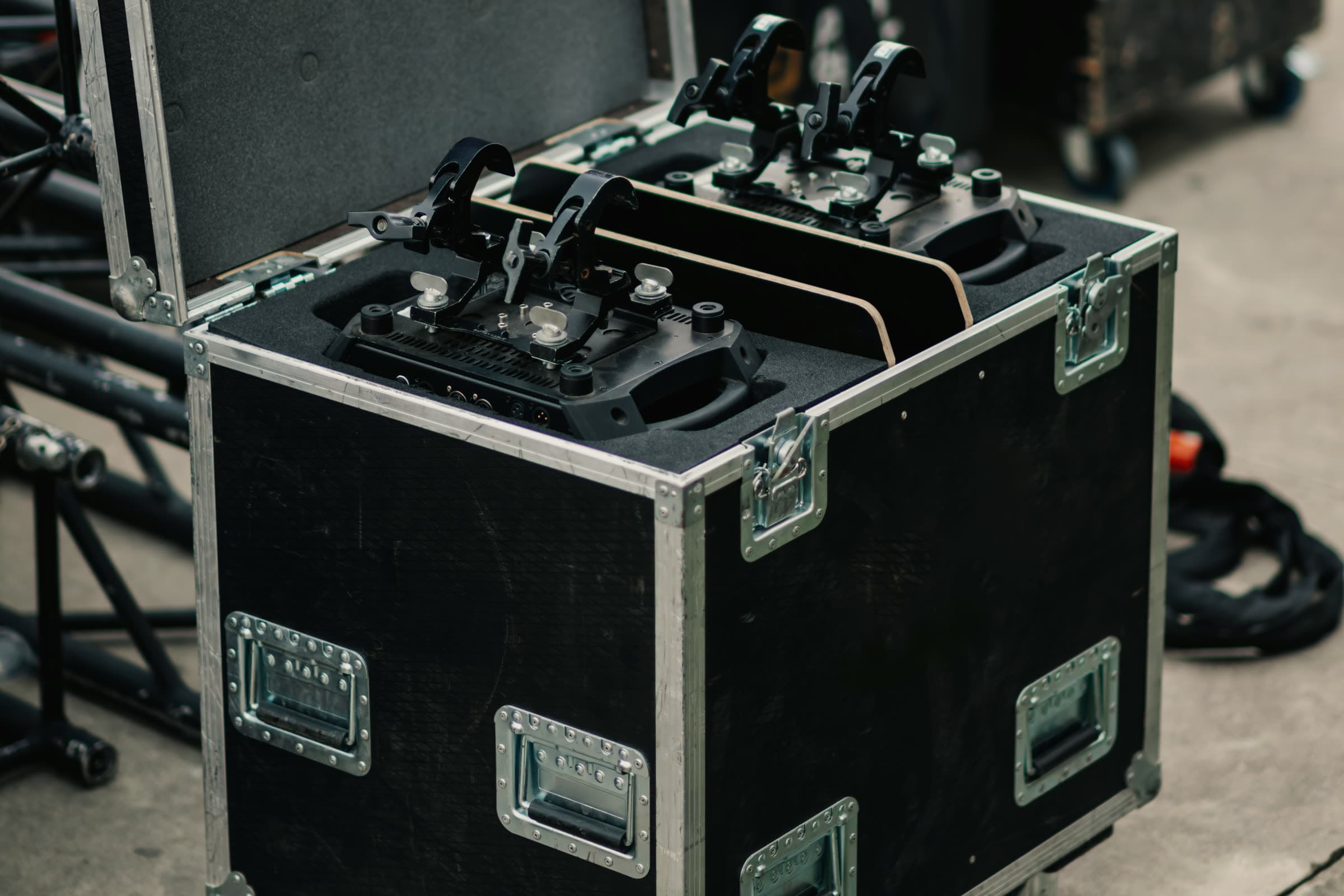 Lighting fixtures packed into an open road case on wheels at a location load-in